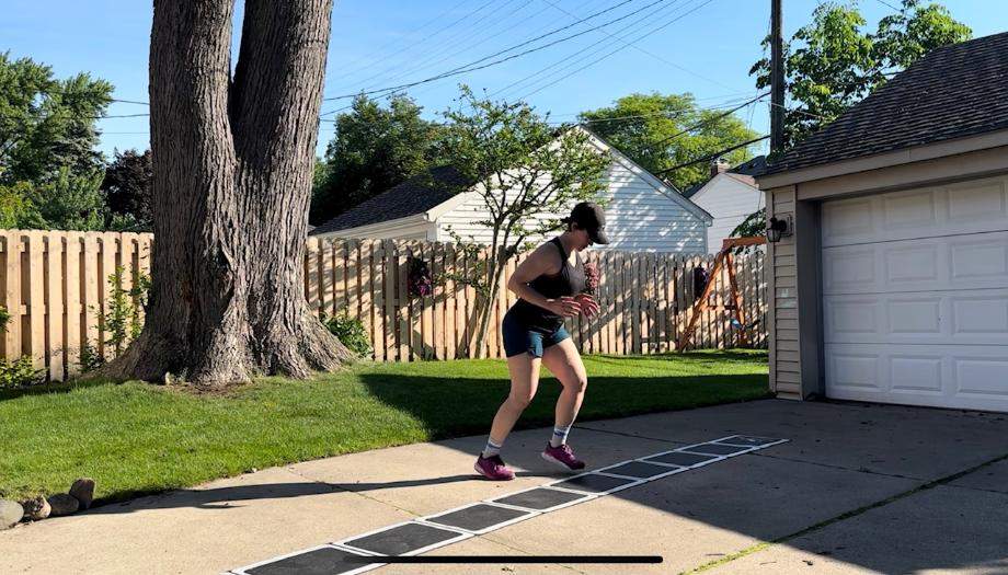 A woman does footwork drills with the Stroops Roll Out Agility Ladder.