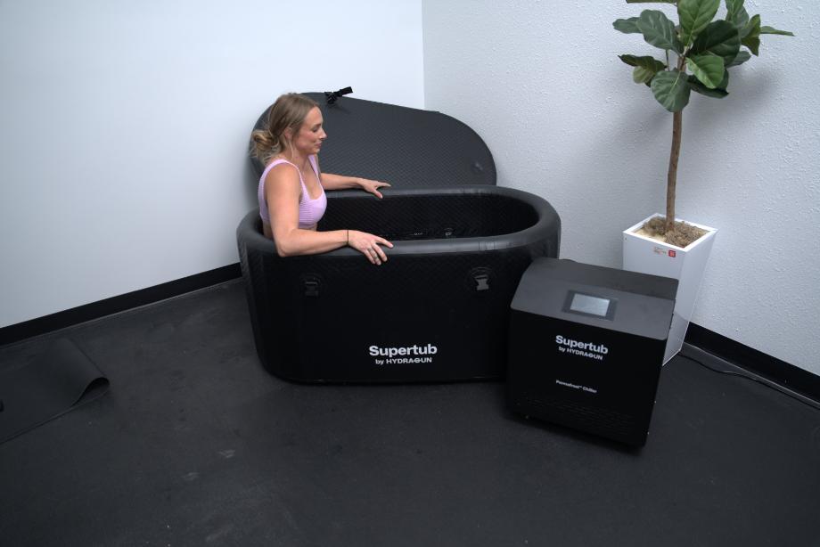 A woman sitting in a Hydragun Supertub Cold Plunge.