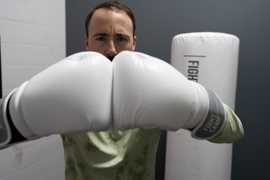 Coop brings his fists together in a pair of white boxing gloves.