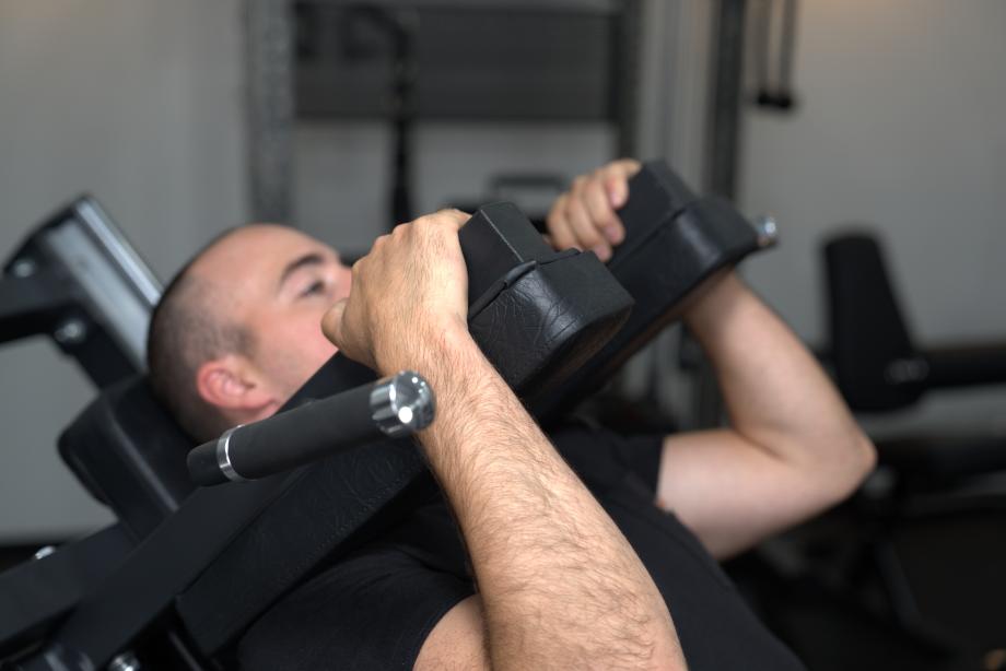 Coop grabs the yoke pads on a Bolt Fitness Hack Squat Leg Press