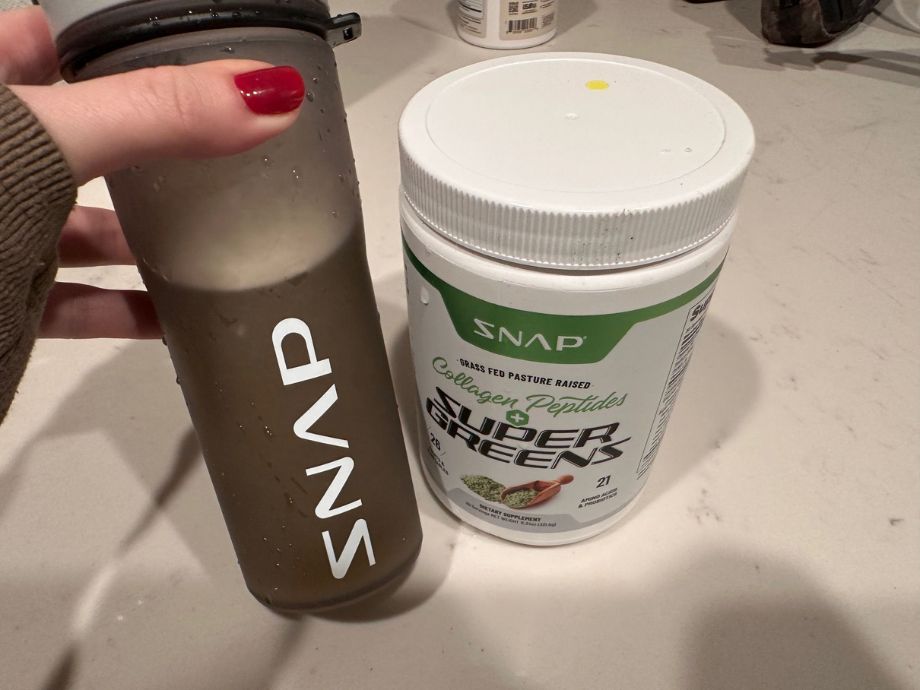 Person holding a shaker bottle mixed with Snap Supplements Collagen & Greens