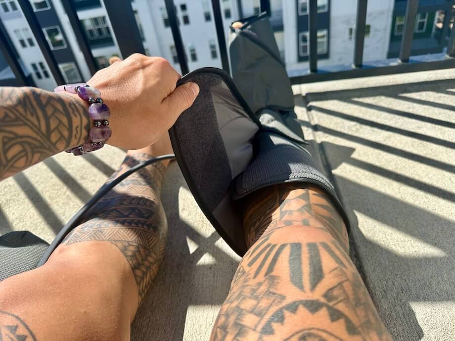 A first-person perspective as someone straps a Fit King Leg Massager around their leg
