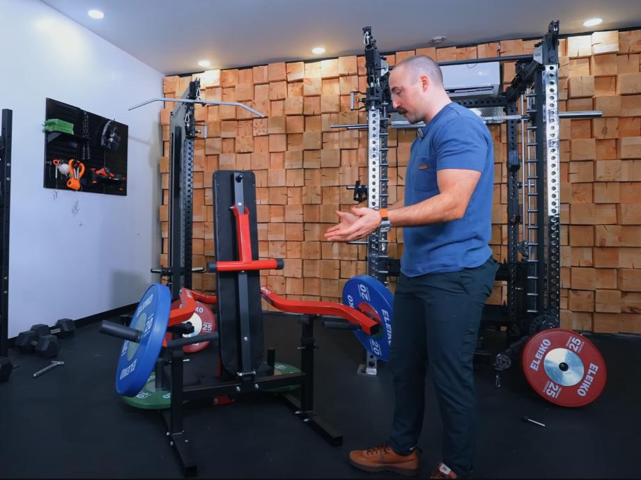 Coop stands next to a GMWD Bench Press Machine in its folded up position.