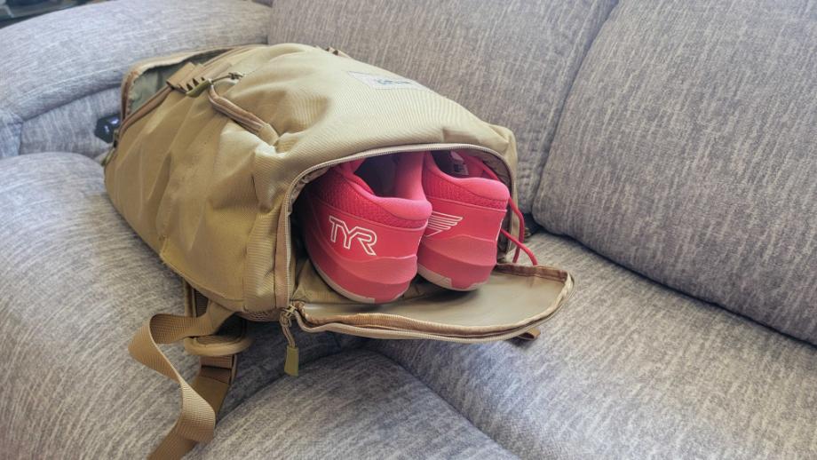 Shoes are shown hanging out of a  KNKG CORE Gym Backpack