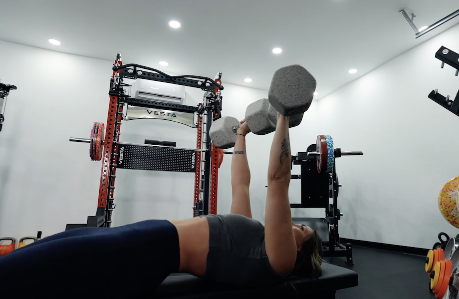 Lindsay Scheele, CPT does bench presses with a pair of Nike Grind Dumbbells