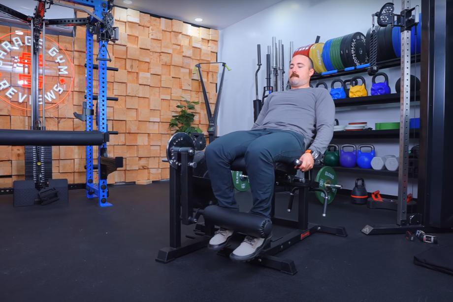 Coop using the RitFit PLC01 Leg Extension Curl Machine for a bottom stretch