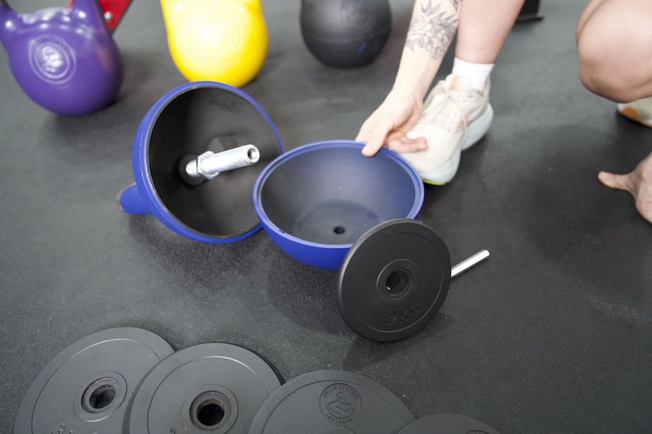 A woman assembling the Bells of Steel Adjustable Kettlebell