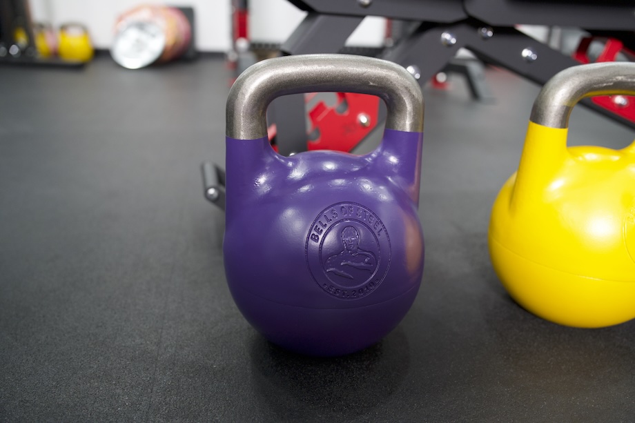 Close-up shot of blue and yellow Bells of Steel Adjustable Kettlebells
