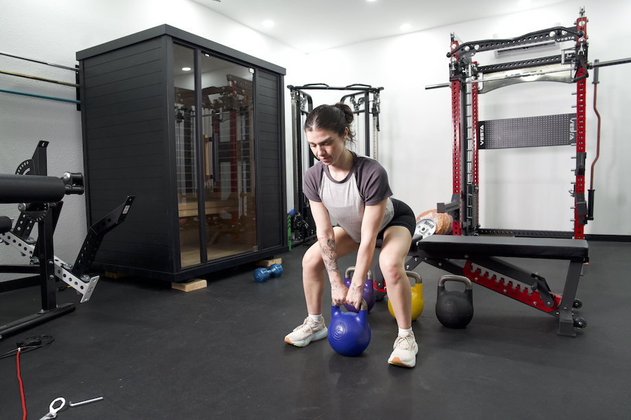 A woman performs a sumo deadlift using a Bells of Steel Adjustable Kettbell