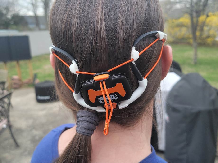 Close rear view of a woman wearing a PETZL Iko Core headlamp