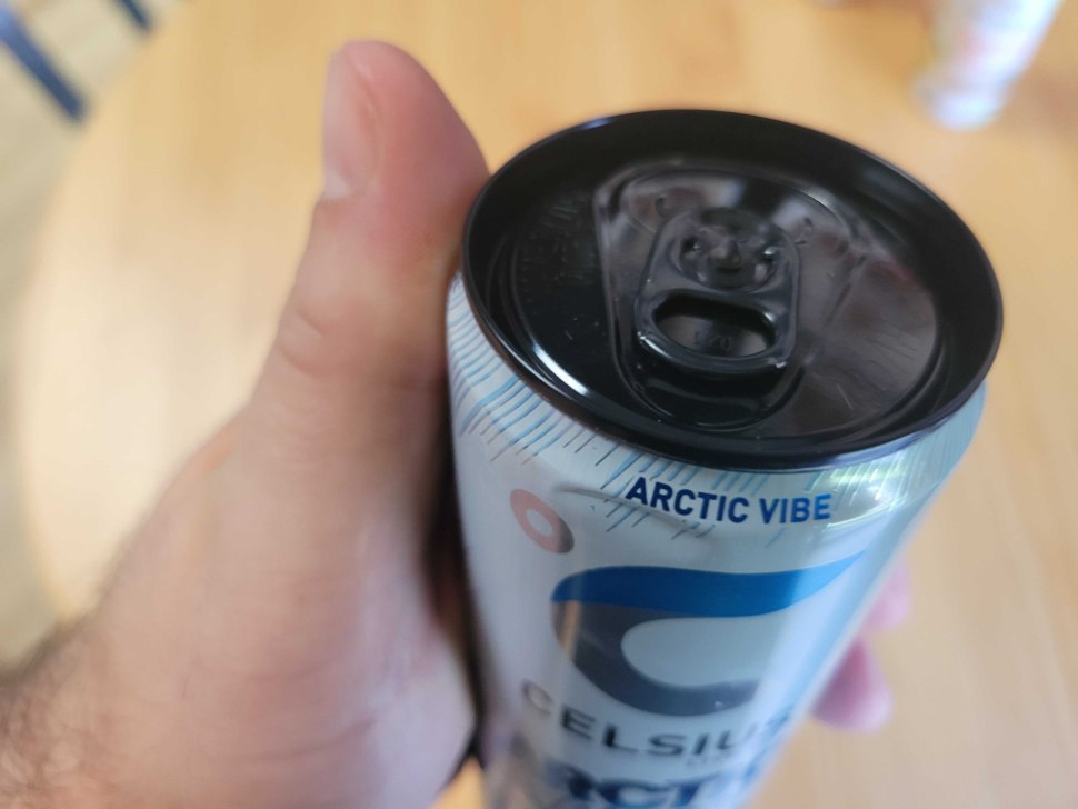 A hand holding a can of Celsius energy drink.