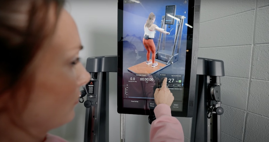 A person uses the touchscreen controls on an Echelon Strength Home.