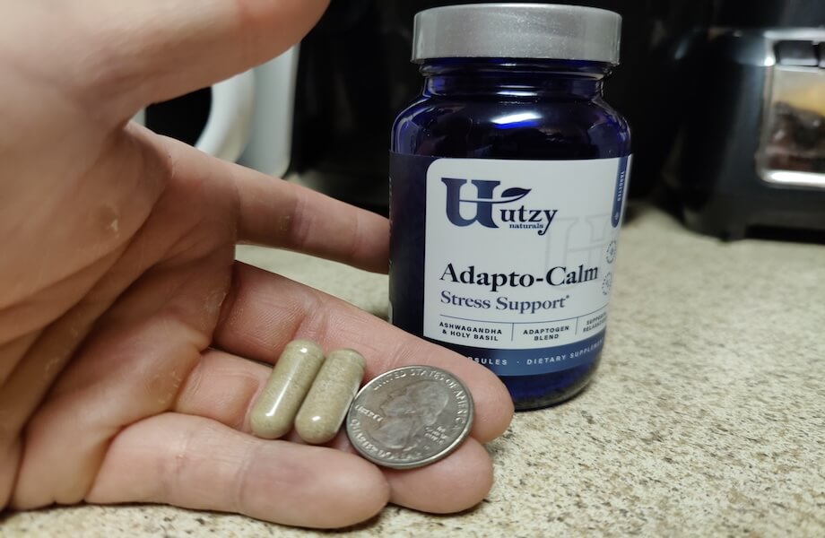 Utzy Adapto-Calm ashwagandha capsule size compared to a quarter