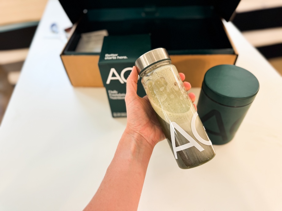 Person shaking up a bottle with Athletic Greens AG1 Next Gen supplement