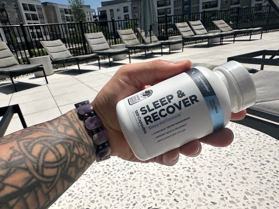 A person holds a bottle of Transparent Labs Sleep Aid & Recover.