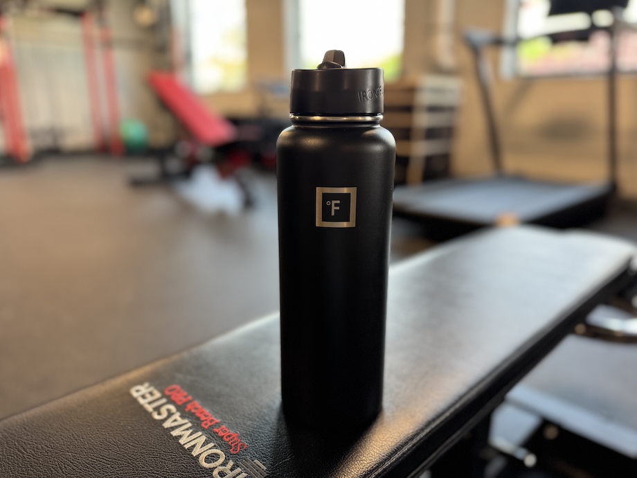Iron Flask Camping & Hiking Hydration Flask on top of a weight bench