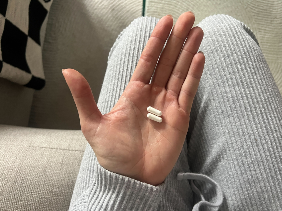 A person holding some Pure Encapsulations Melatonin capsules.
