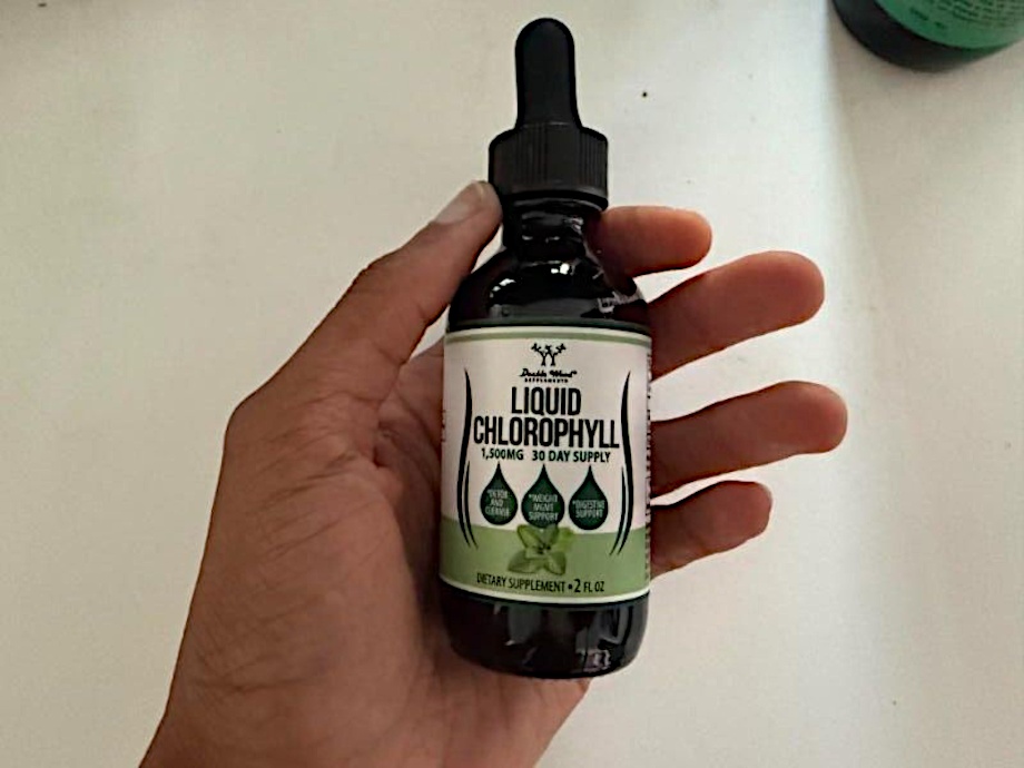 Our tester holds up a bottle of Double Wood Liquid Chlorophyll