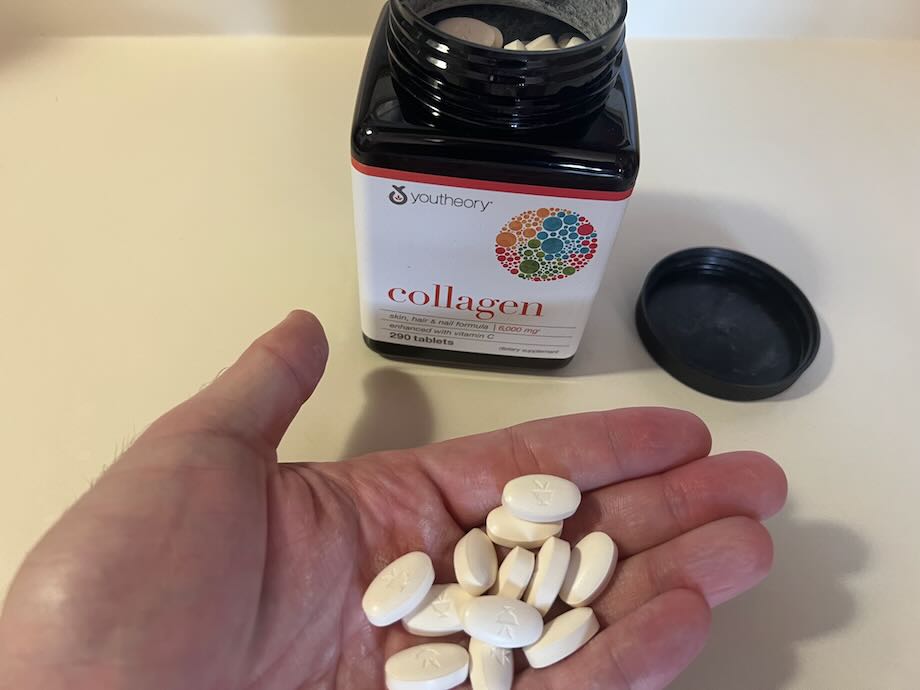 Hand holding YouTheory Collagen tablets