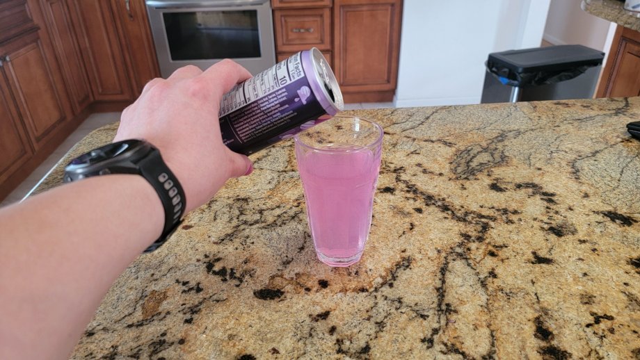 Pouring a can of Alani Nu into a glass