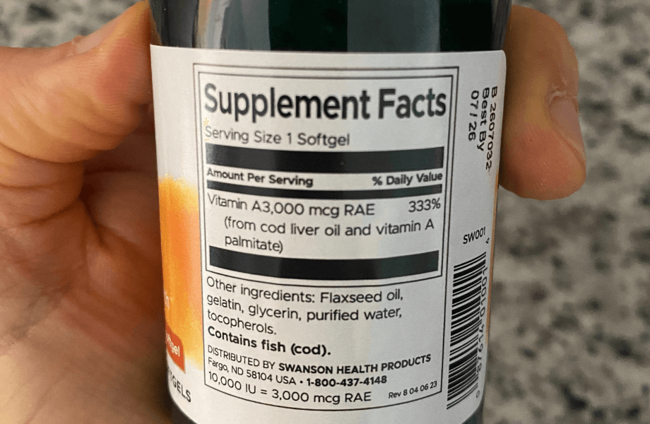 Our tester reading the supplement facts of Swanson Vitamin A 10,000 IU Softgels