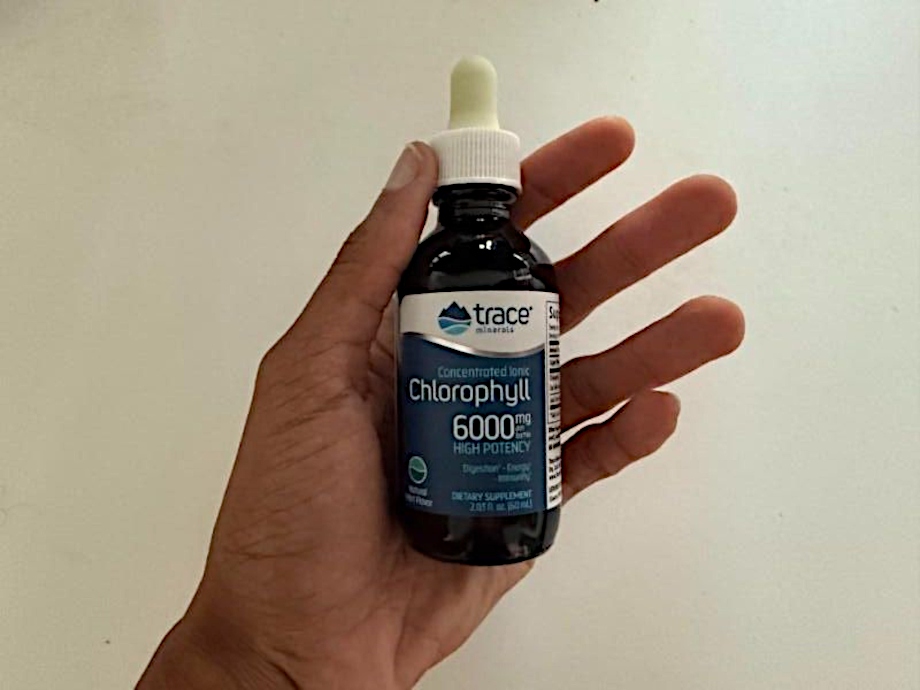 Our tester holds up a bottle of Trace Ionic Chlorophyll