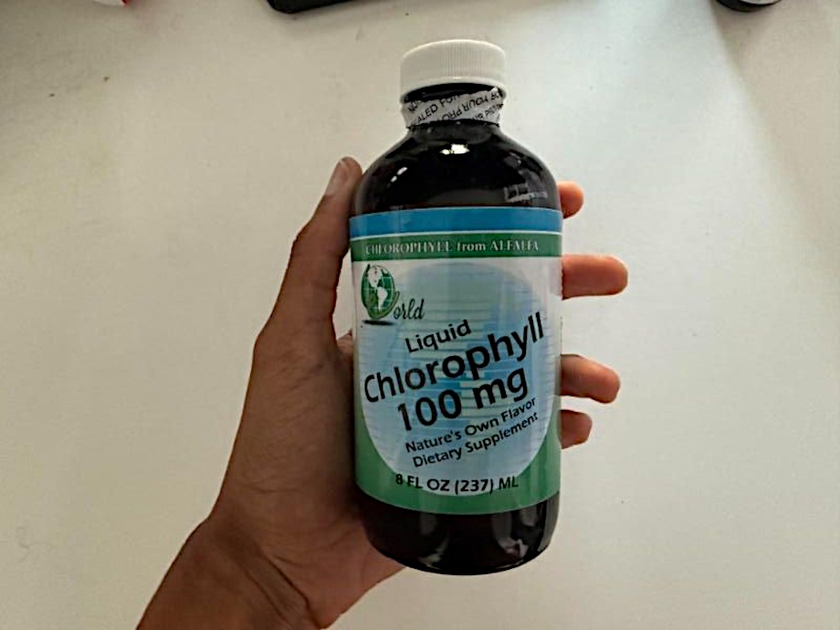 Our tester holds up a bottle of World Organic Liquid Chlorophyll