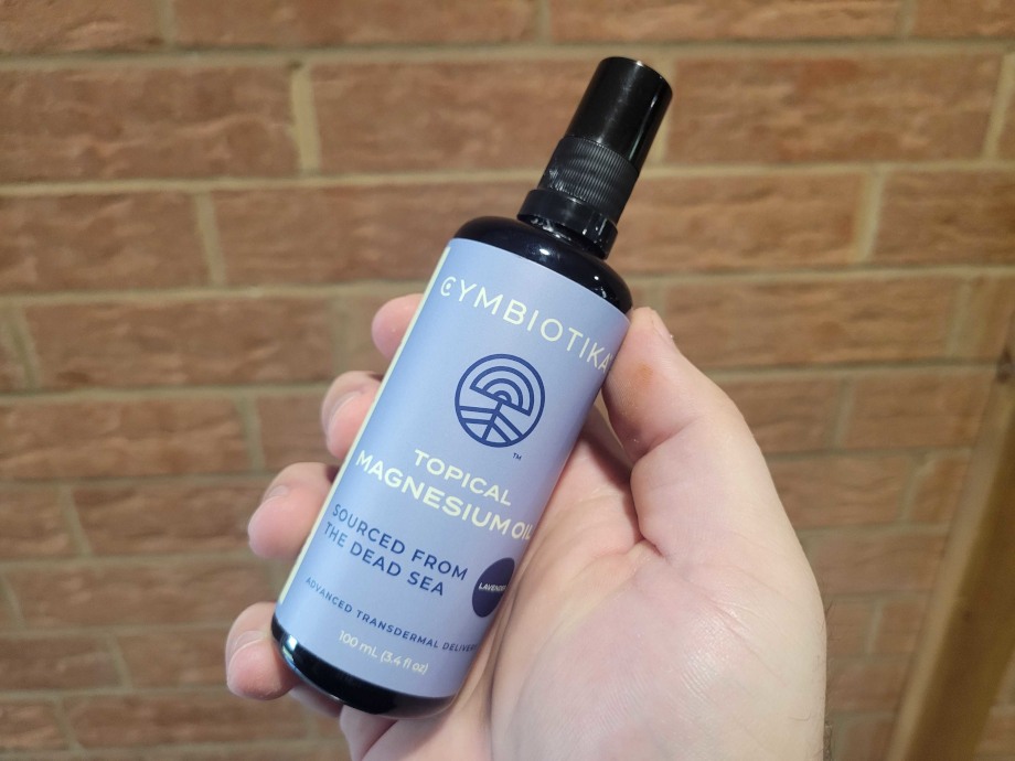 Our tester holds a bottle of Cymbiotika Topical Magnesium