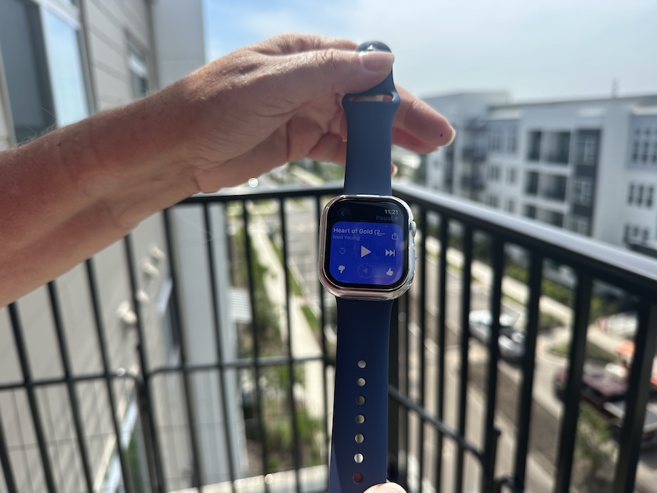 Holding Apple Watch Series 10 by the band