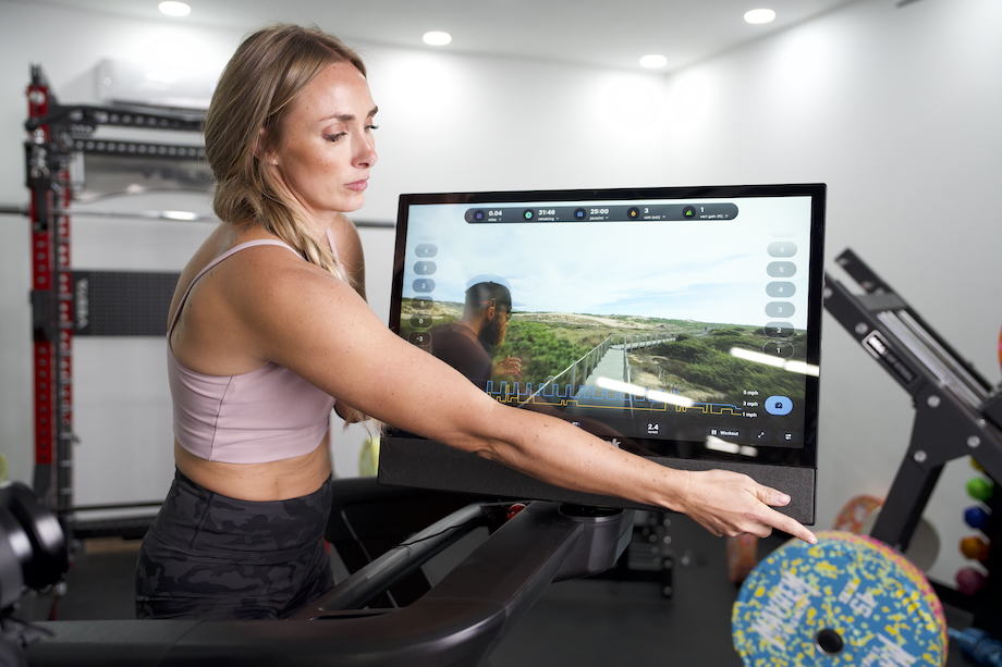GGR Everything lead reviewer Lindsay Scheele showing the touchscreen display on the NordicTrack Commercial 2450 treadmill