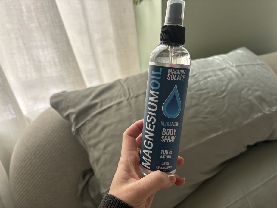 Our tester holds a bottle of Magnum Solace Ultra Pure Magnesium Oil Body Spray