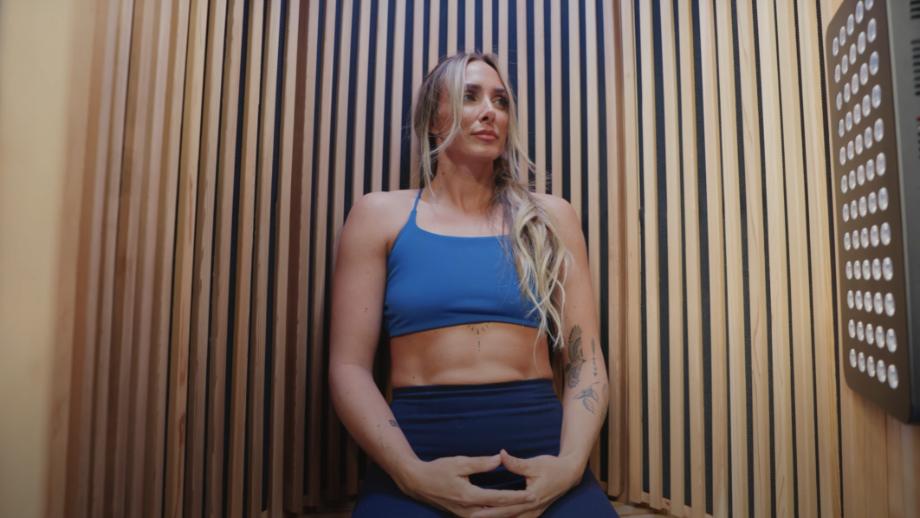 Expert tester Lindsay Scheele, CPT, sits with her hands in a meditative mudra in a Sun Home Pod Sauna.