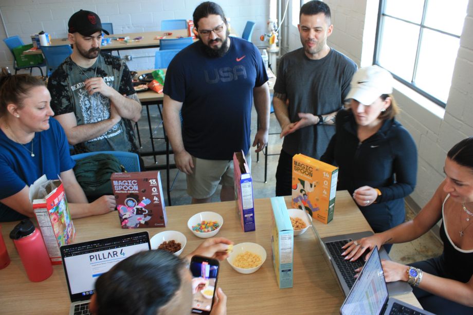 The Garage Gym Reviews team stands around a table sampling Magic Spoon Cereal