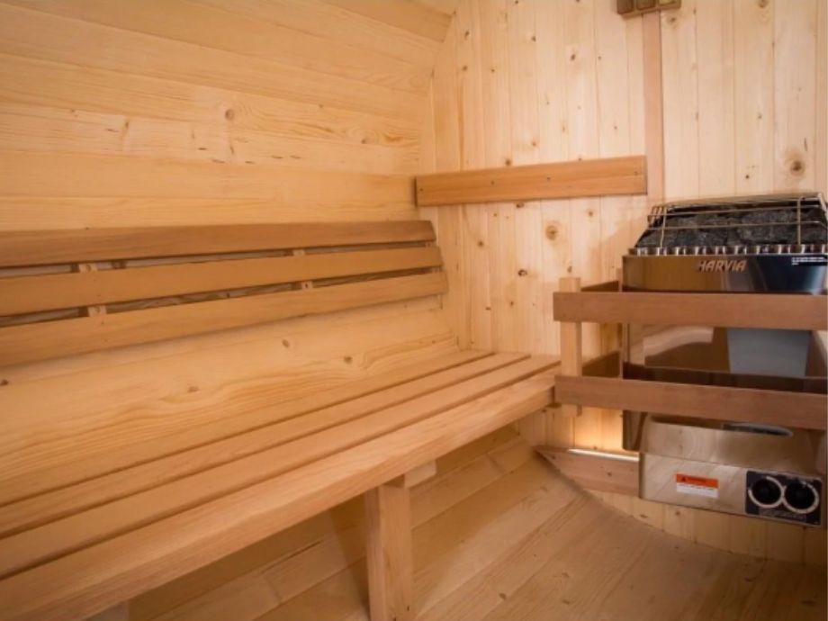 Bench and heater inside the Almost Heaven Morgan Barrel Sauna