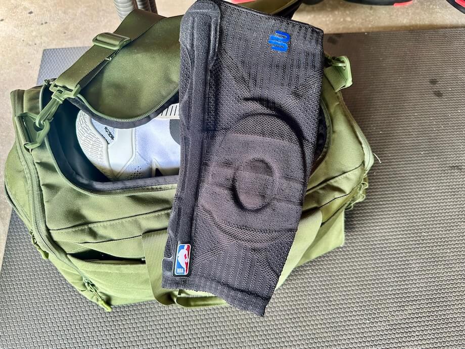 A Bauerfeind Sports Knee Support lays on a sports bag
