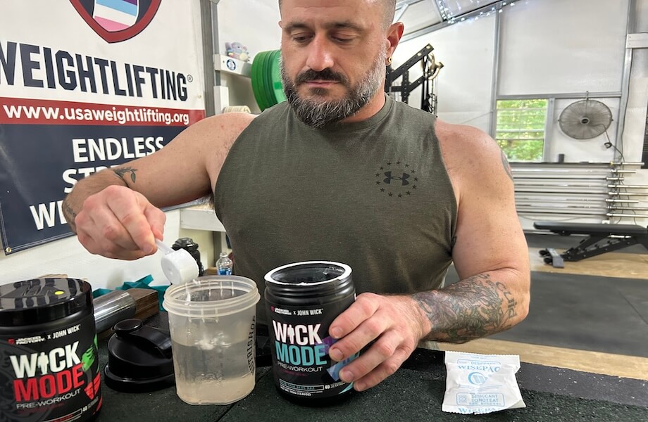 Our tester pouring a scoop of Jacked Factory Wick Mode pre-workout into their shaker bottle