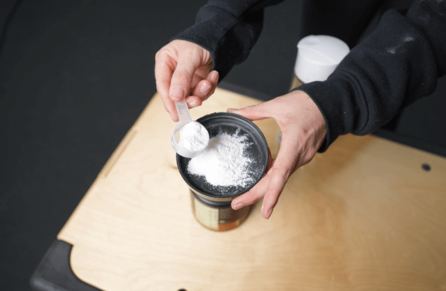 Our tester grabbing a scoop of Optimum Nutrition Gold Standard Pre-Workout