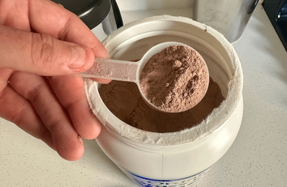 Our tester grabbing a scoop of Orgain Grass-Fed Whey Protein
