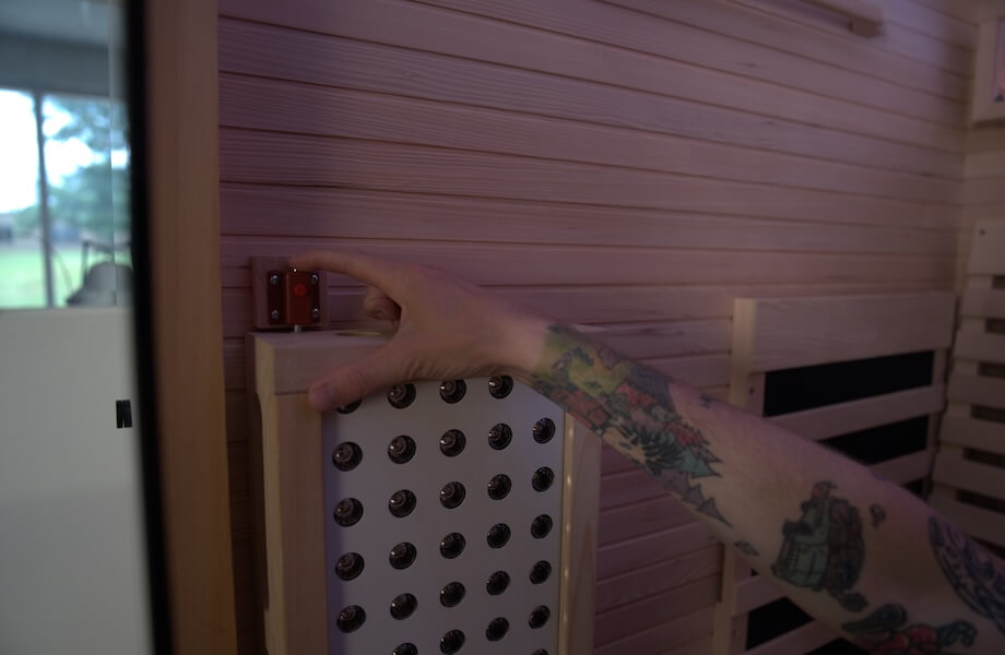 Our tester locking the Relaxe Caldera Infrared Sauna's integrated red light therapy panel into position