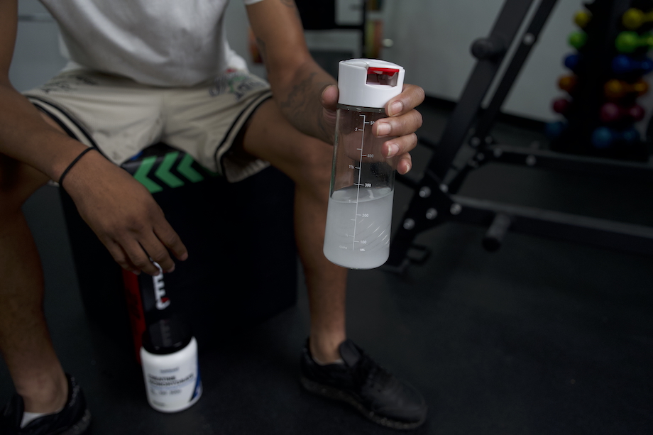 Product tester holding a water bottle mixed with Nutricost Creatine