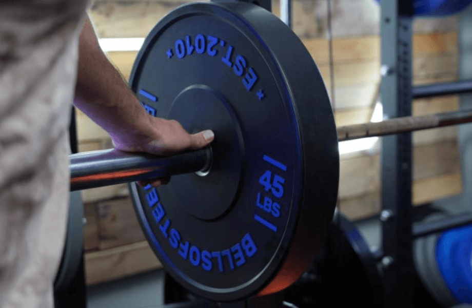 A Bells of Steel Dead Bounce Bumper Plate loaded onto a barbell