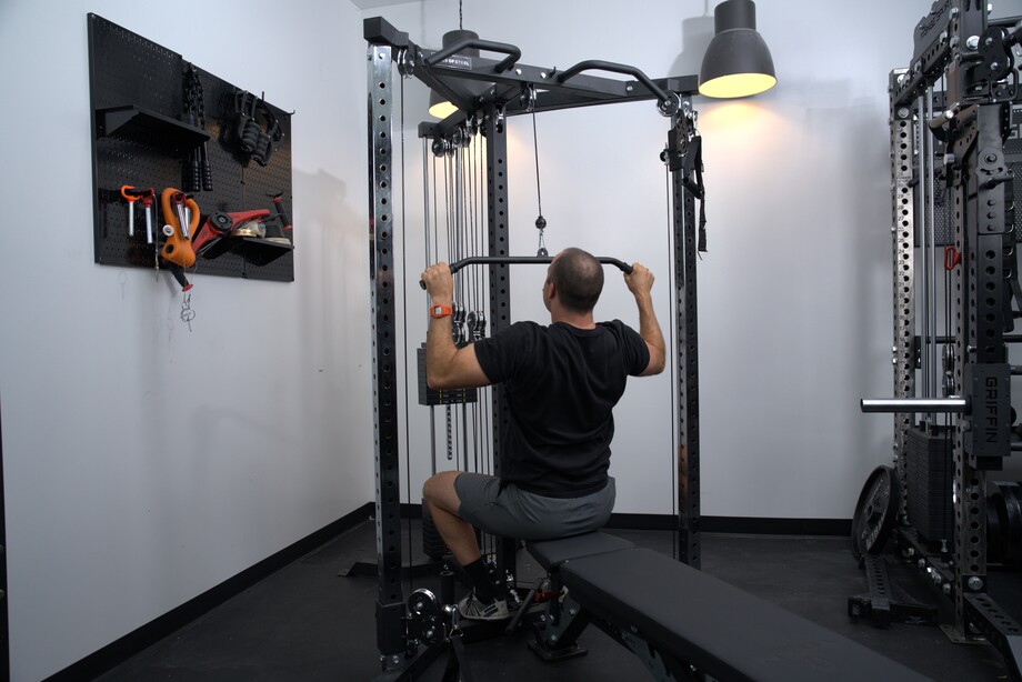 A man performing lat pulldowns on the Bells of Steel All-in-One Home Gym