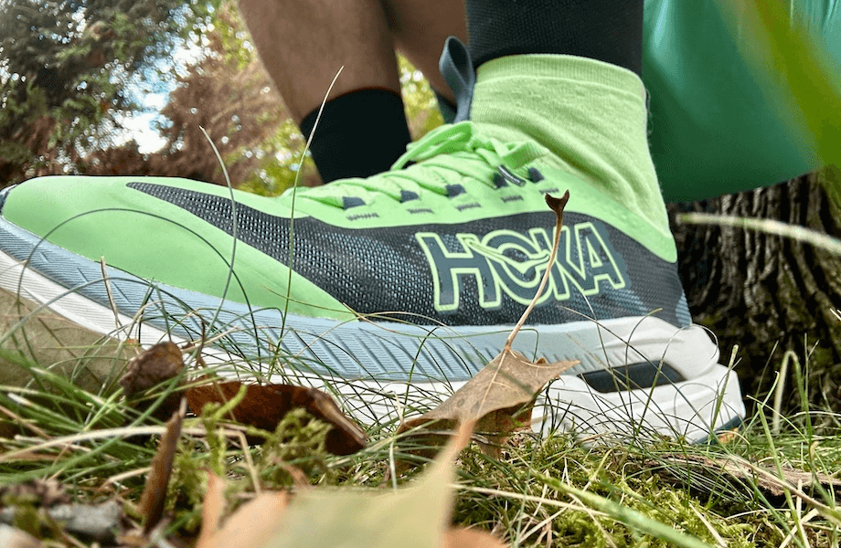 Our tester crouching in a pair of HOKA Tecton X 3 trail running shoes
