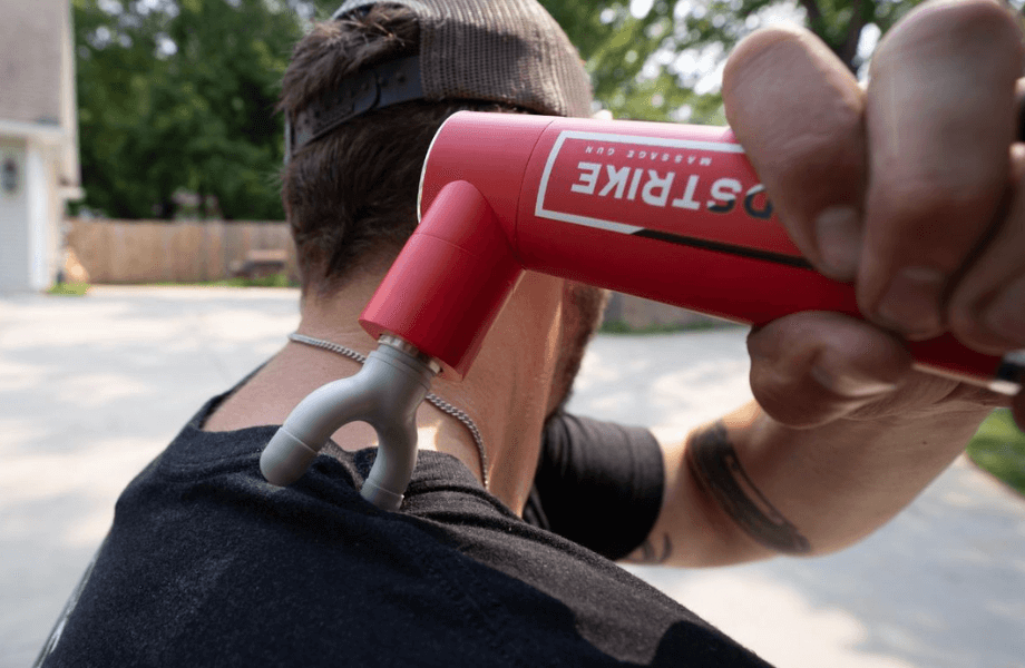 Our tester using the REP Rapidstrike Massage Gun on their shoulder