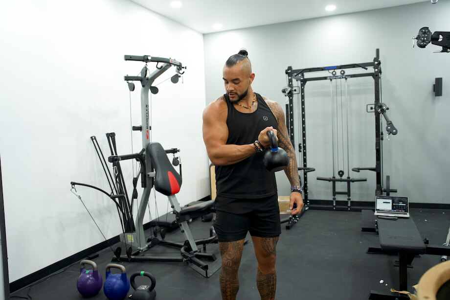 Product tester performs a biceps curl with the Rogue E-Coat Kettlebell