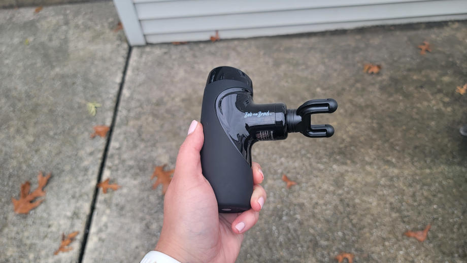 A person holding the Bob & Brad M7 Plus mini massage gun.