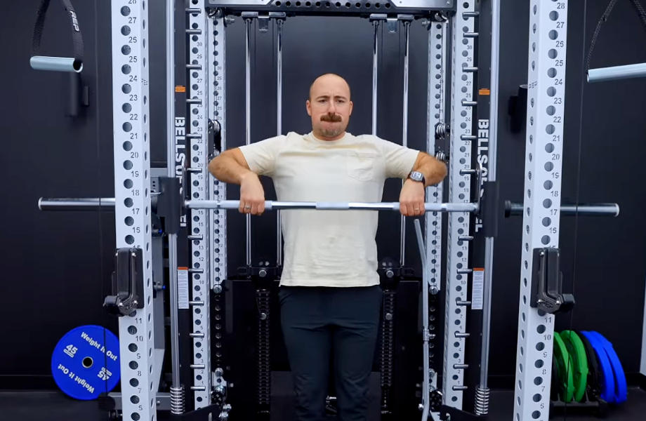 A man is shown working out with the Bells of Steel Smith Machine Attachment