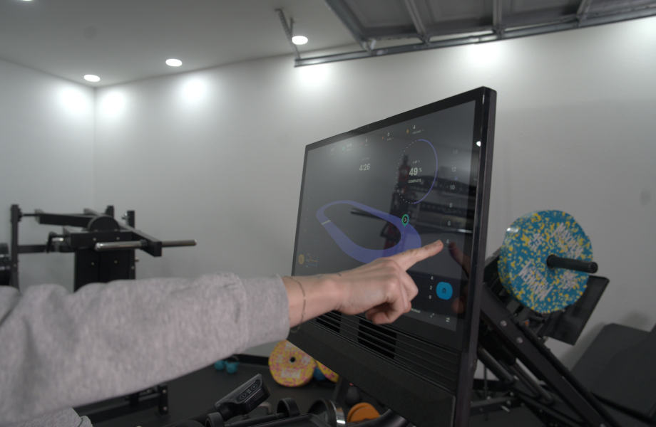 Our tester Interacts With the touchscreen on a Nordictrack X24 Bike