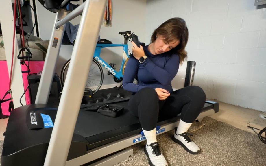 A woman uses the Bob & Brad Q2 Mini Pro on her trap muscles.