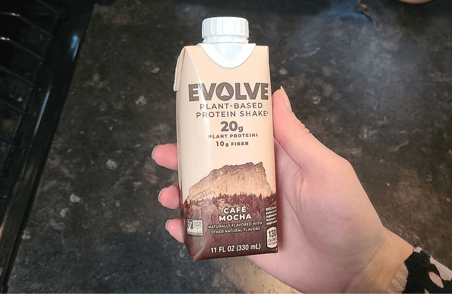 Our tester holding a single carton of Evolve Plant-Based Protein Shake